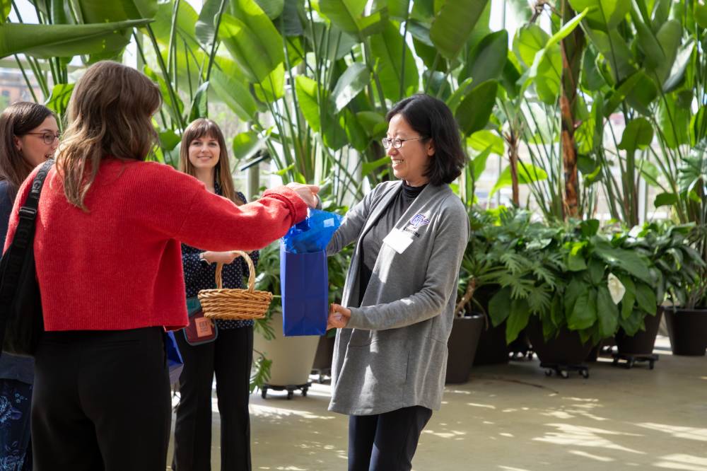 Female party goer receiving gift bag from colleague